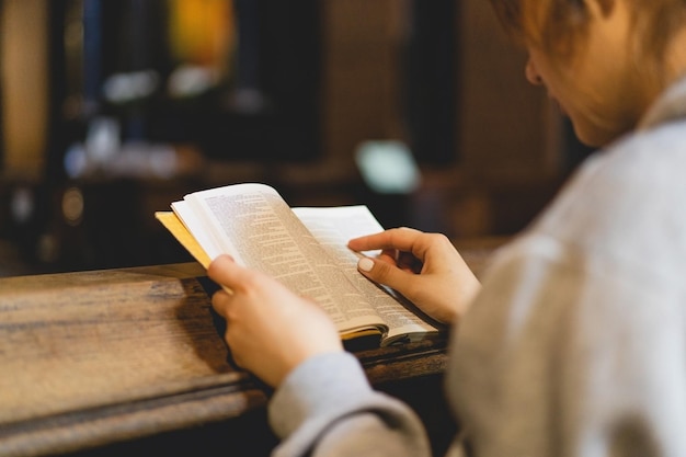 Foto christliche frau liest die bibel in einem alten katholischen tempel und liest die heilige bibel im tempel. konzept für glauben, spiritualität und religion. konzept für frieden, hoffnung und träume