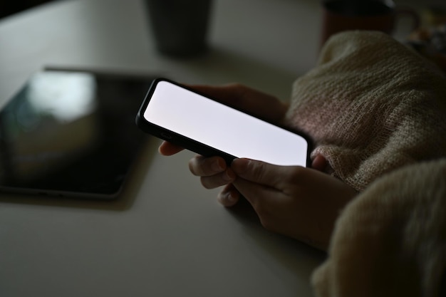 Closeup imagem Mãos femininas segurando uma maquete de tela branca de smartphone