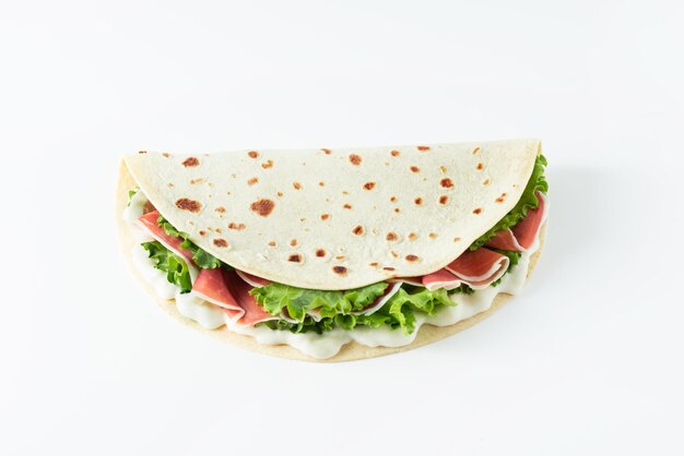 Foto comida de rua italiana plana com piadina isolada em um fundo branco piadina romagnola pão italiano com salada de presunto e cream cheese