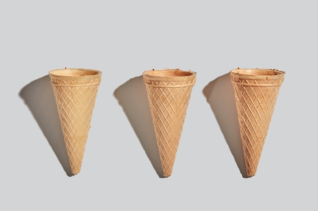 Cones de waffle doce para sobremesa vazia em um fundo de papel branco com espaço de cópia. Conceito de comida de primavera ou verão. Vista do topo.