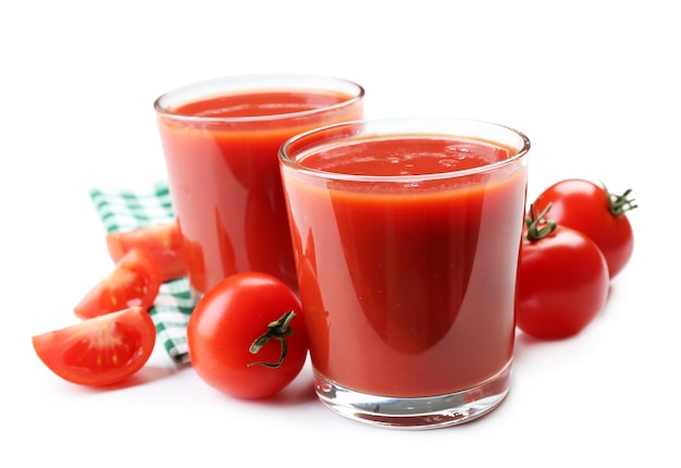 Copos de suco de tomate fresco em guardanapo quadriculado isolado em branco