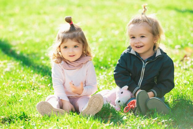 Foto criança bebê na grama verde no parque de verão irmão e irmã brincam juntos em um prado verde happ