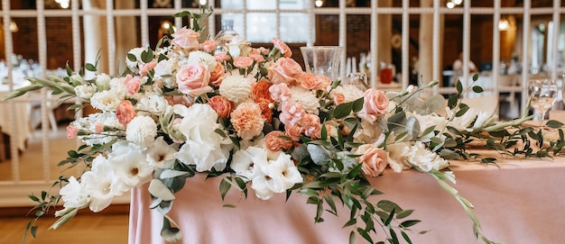 Decoração de mesa com flores e tecido para cerimônia de casamento em banquete