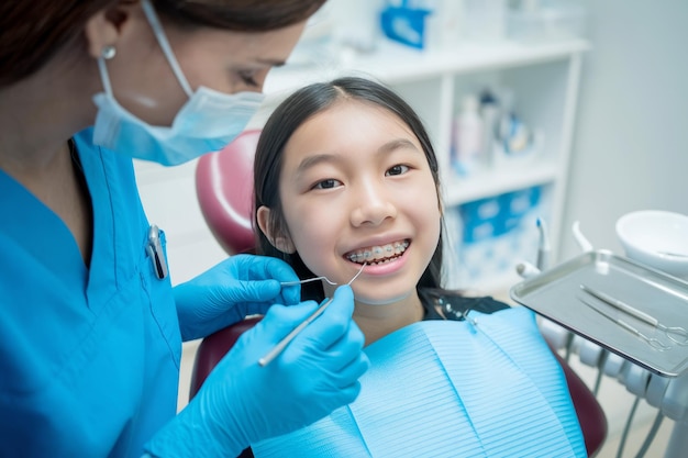 Foto dentista examinando os dentes de uma menina durante uma consulta