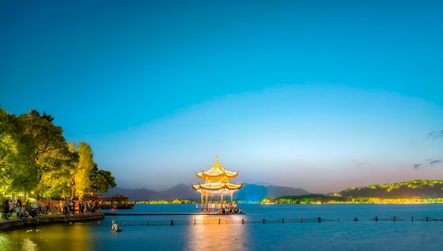 Der ruhige See mit dem traditionellen asiatischen Pavillon in der Dämmerung