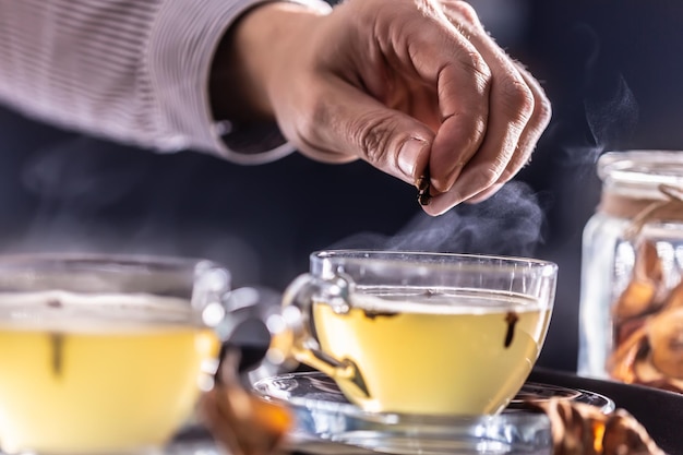 Detalhe da mão de um barman aromatizando vinho quente com cravo