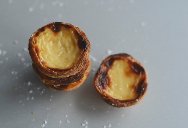 Foto eierkuchen traditionelles portugiesisches dessert pastel de nata pasteis auf einem teller grauer steinhintergrund