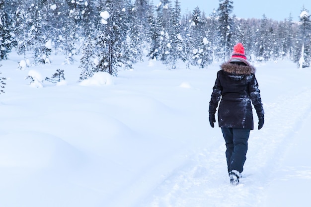 Eine Frau, die im Schnee spazieren geht