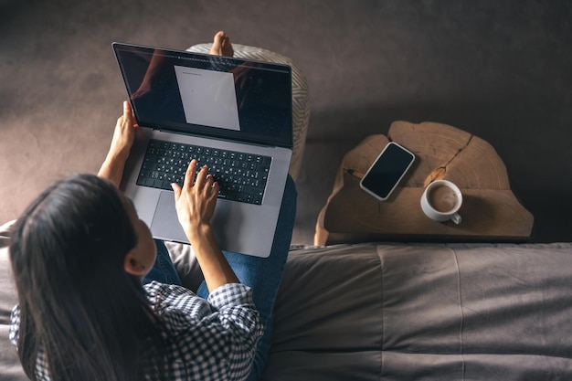 Eine junge Frau arbeitet zu Hause an einem Laptop