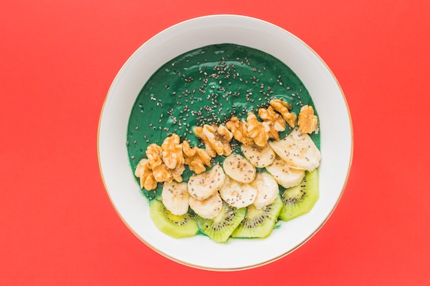 Eine Spirulina-Smoothie-Schüssel mit Bananen-, Walnuss-, Kiwi- und Chiasamen