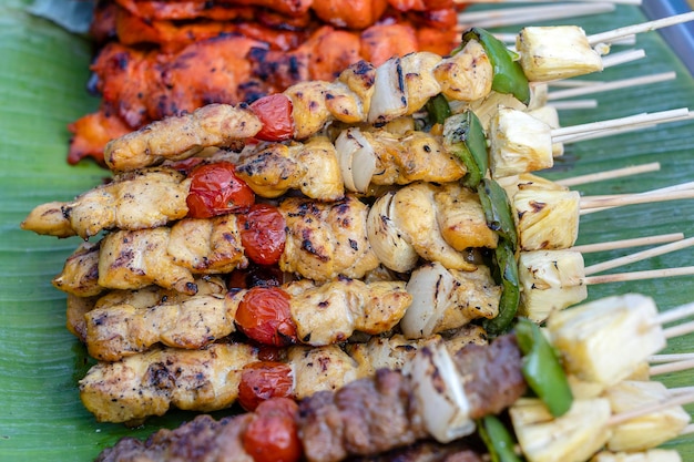 Espetos com pedaços de churrasco grelhado pimentão verde tomate vermelho e carne para venda no mercado de rua Tailândia closeup