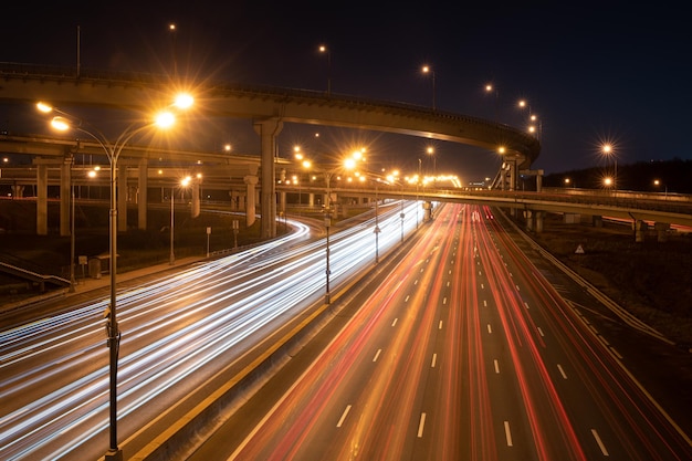 Estrada moderna à noite com trilhas leves de carro