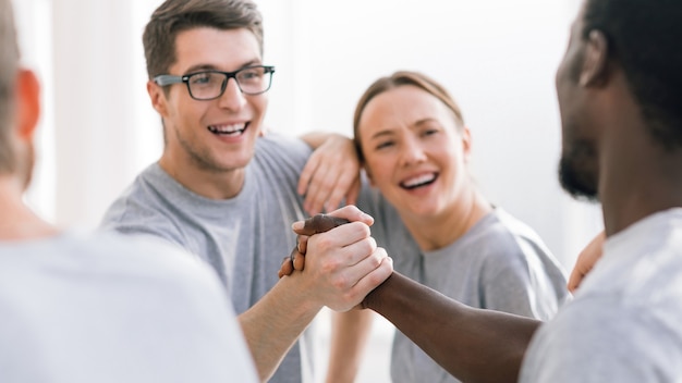 Fechar-se. participantes do encontro internacional apertando as mãos. o conceito de unidade