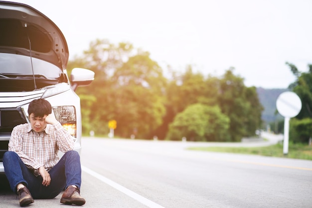 Feche a mão do empresário usando um telefone inteligente móvel, ligue para um mecânico de automóveis, peça ajuda, porque o carro quebrado na estrada pessoas viajam amigos sentam-se esperando ao lado do carro quebrado