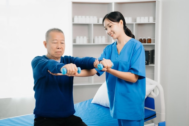 Foto fisioterapeuta asiático ajudando homem idoso paciente esticando o braço durante o exercício correto com halter na mão durante o treinamento mão com paciente problemas nas costas