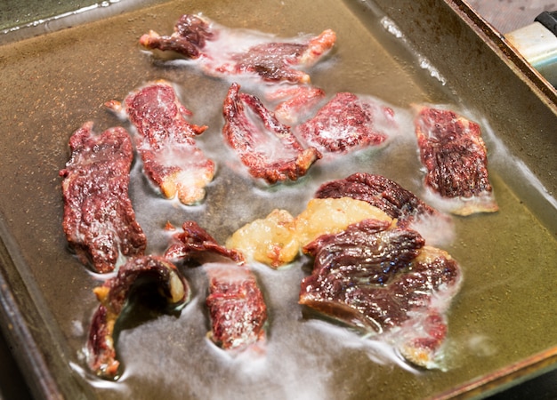 Foto fleisch in einer pfanne braten