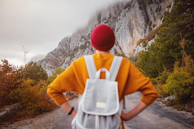 Foto de moda ao ar livre de uma jovem linda cercada pela floresta de outono nas montanhas