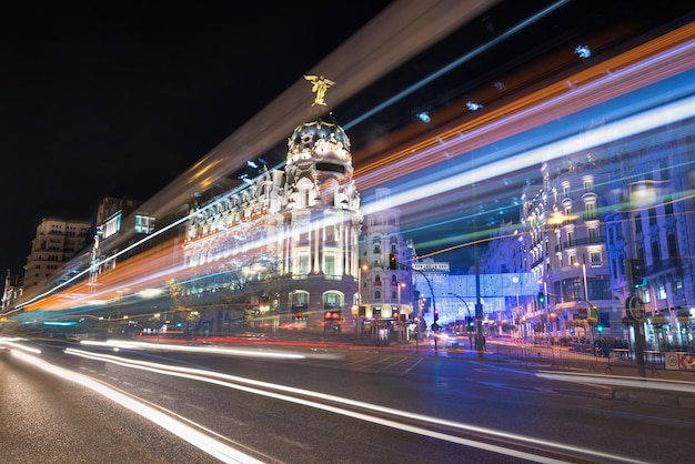 Fotografia da noite da arquitectura da cidade de Madrid, rua de Gran Via com raios do sinal. Madri, Espanha.