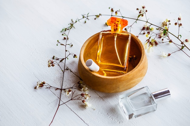 Foto frasco de perfume com flores sobre fundo branco de madeira