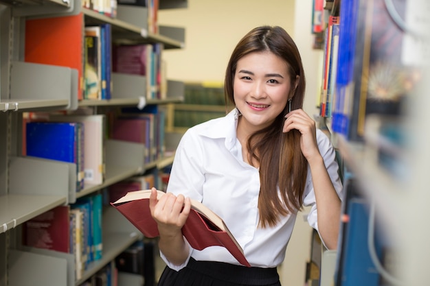 Frau im Vordergrund hält Bücher für das Lesen.