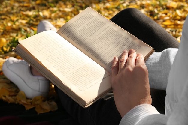 Foto frau lesebuch im freien am herbsttag nahaufnahme