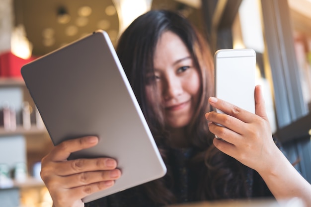 Frau mit Tablet PC und Telefon