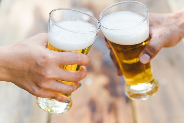 Foto freunde, die beim camping im freien eine flasche bier klirren