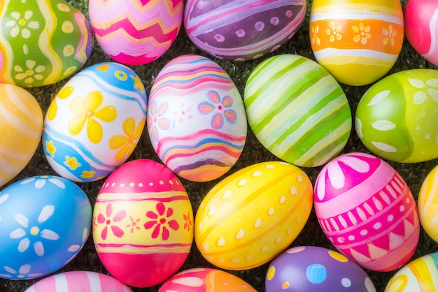 Frohe Ostern mit bunten Eiern am Pinsel zum Selbermachen auf dem Rasen mit Nahaufnahme von oben