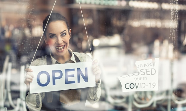 Funcionário feliz por estar de volta ao trabalho quando o restaurante reabre após o fechamento devido ao covid19