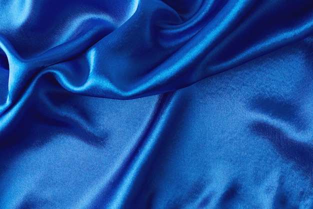 Fundo de seda azul com dobras. Textura abstrata da superfície de cetim ondulada