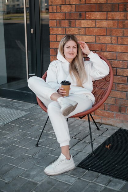 Garota de capuz branco com café para sair do café