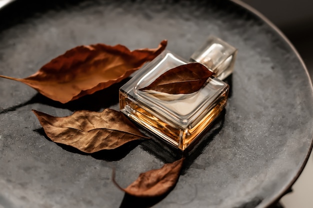 Foto garrafa de eau de parfum feminino com folhas de outono