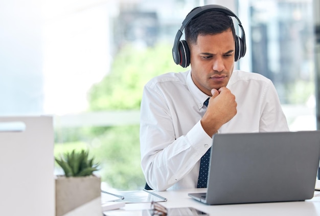 Geschäftsmann-Laptop und Denken über Entscheidungsfindung oder Musikhören am Schreibtisch. Ein Buchhalter oder Finanzberater wundert sich, der am Computer für Geschäftsplanvorschläge oder -ideen arbeitet