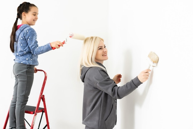 Glückliche junge Familie mit kleiner Tochter, die die Wand malt.