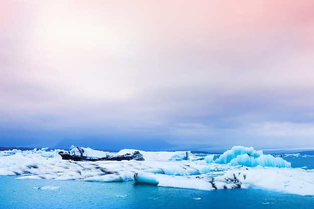 Grandes icebergs azuis na lagoa glacial de Jokulsarlon, sul da Islândia. Bela paisagem ao pôr do sol