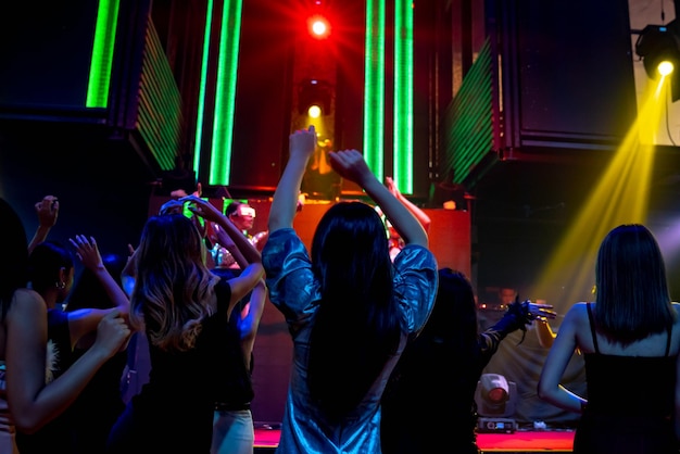 Foto grupo de pessoas dança na discoteca ao ritmo da música do dj no palco