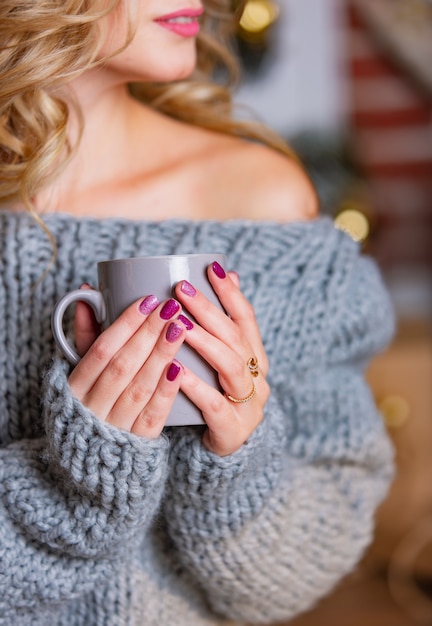 Hand der Frau, die eine Tasse Tee anhält