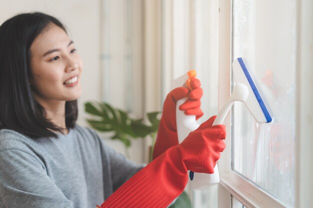 Foto haushälterin reinigung nach hause konzept. sprühreiniger der frau zum fenster.