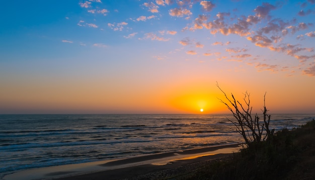 Heller bunter Sonnenaufgang an der Küste