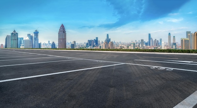 Hintergrund der Asphaltdecke und der urbanen architektonischen Landschaftsskyline