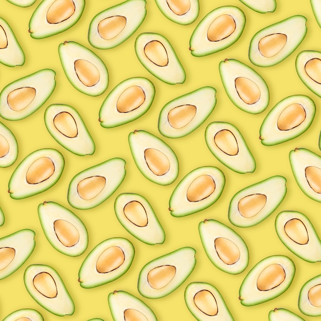 Hintergrund von reifen Avocadohälften auf gelbem Hintergrund. Als Hintergrund wird die Pantone-Farbe 2021 verwendet: 13-0647 Illuminating.