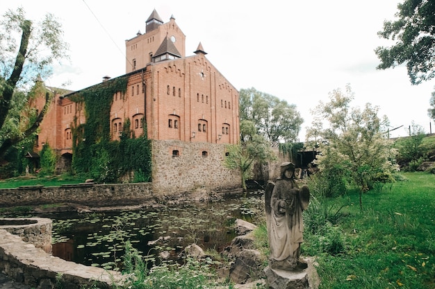 Historisches schönes Ziegelstein- und Steinschloss bedeckt mit Lianen