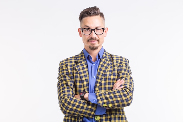 Homem bonito na jaqueta com barba e bigode em copos, com os braços cruzados, em pé sobre um fundo branco com espaço de cópia.