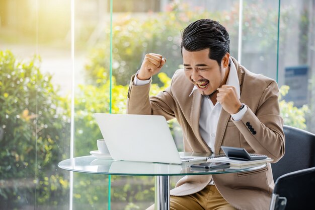 Foto homem de negócios bem sucedido feliz usando computador portátil