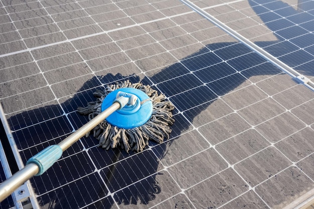 Homem limpa os painéis solares que estão sujos com poeira e excrementos de pássaros