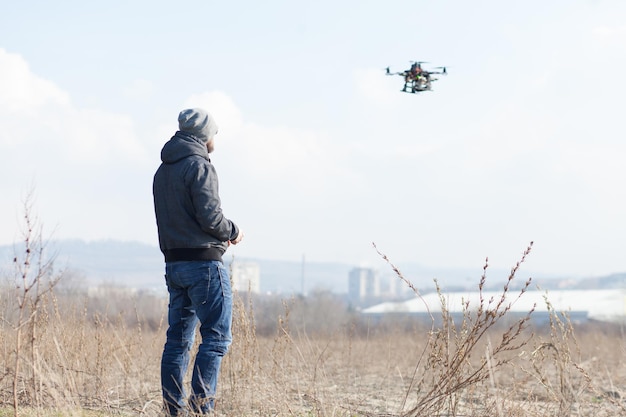 Foto homem operando quadcopter contra o céu