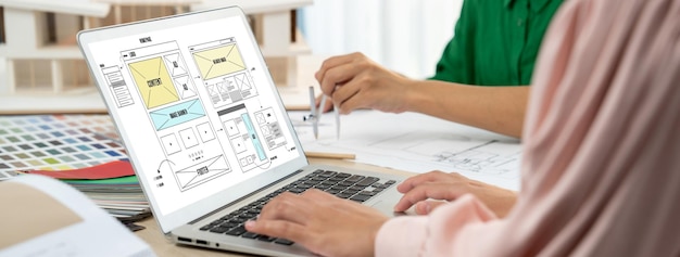 Foto imagem recortada da equipe de designer de interiores discutindo a cor do material enquanto o laptop exibia designs de wireframe de sites para aplicativos móveis e sites design criativo e conceito de negócios variados