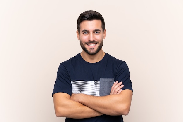 Jovem bonito com barba mais isolado mantendo os braços cruzados na posição frontal