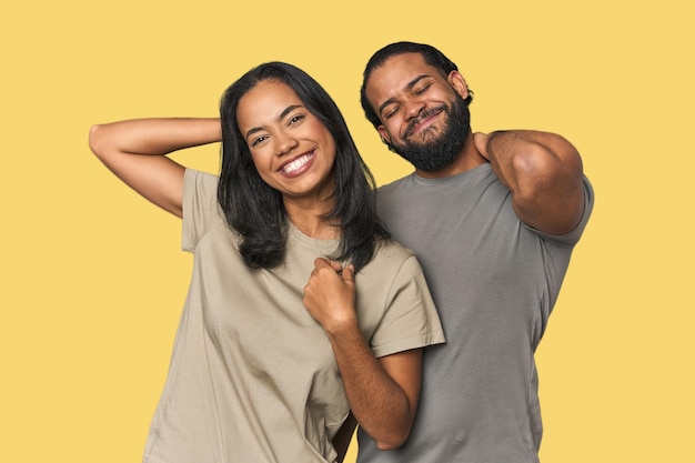 Foto jovem casal latino em estúdio esticando os braços em posição relaxada