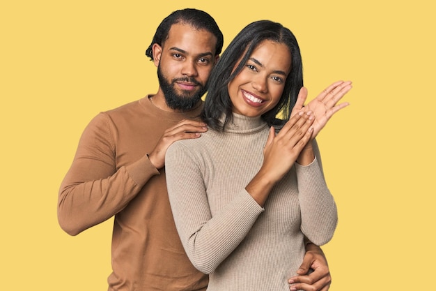 Foto jovem casal latino no estúdio sentindo-se enérgico e confortável esfregando as mãos confiante